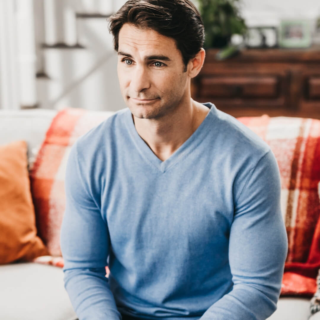 pensive man sitting on couch