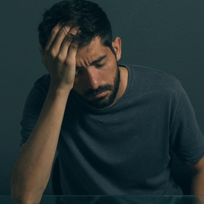 upset depressed man holding head