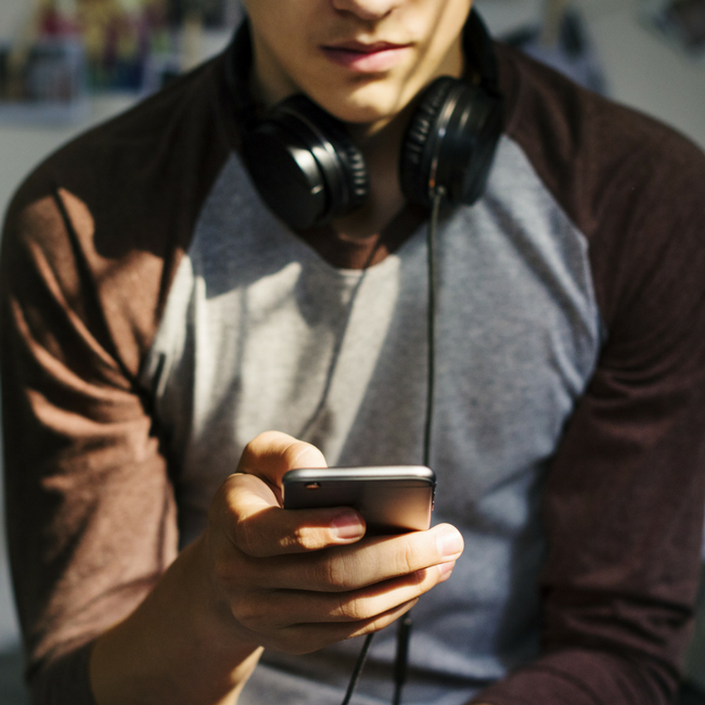 teenage male on cell phone in bedroom