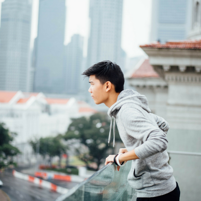 young asian man looking over balcony