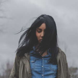 young woman outside looking down