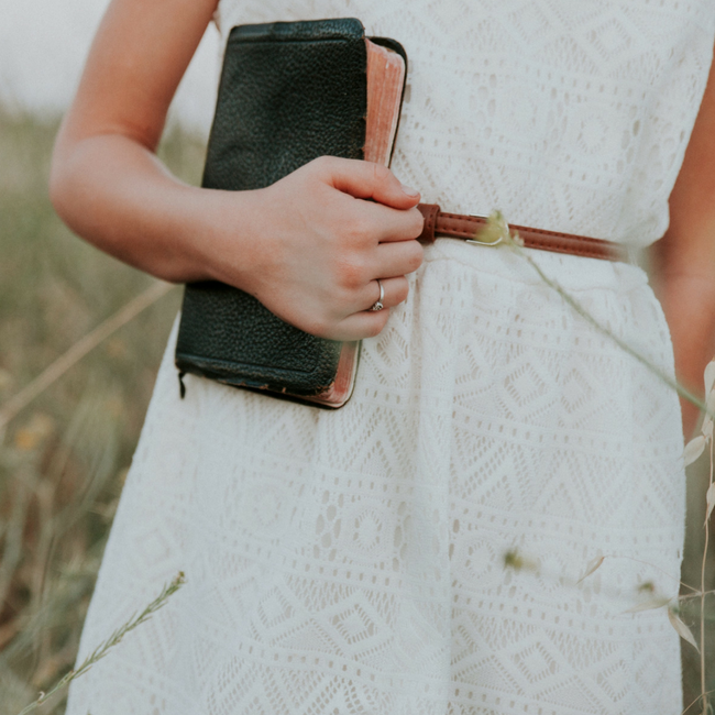 girl holding bible in white dress