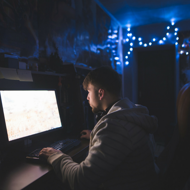 man playing computer games in dark room