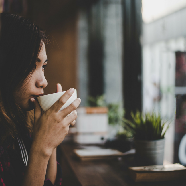pensive woman drinking cup of coffee