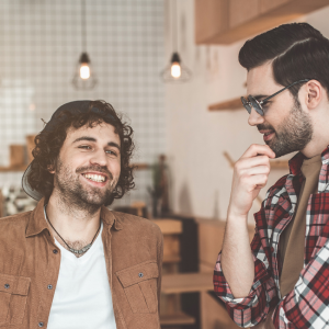 two guy friends talking at coffee shop