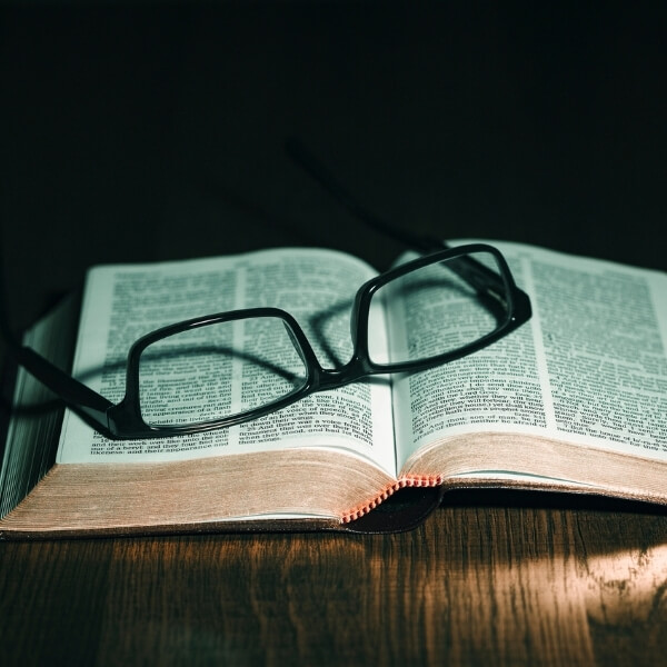 pair of glasses on open bible
