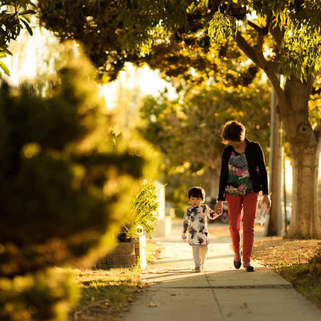 grandma and young granddaughter walking on sidewalk