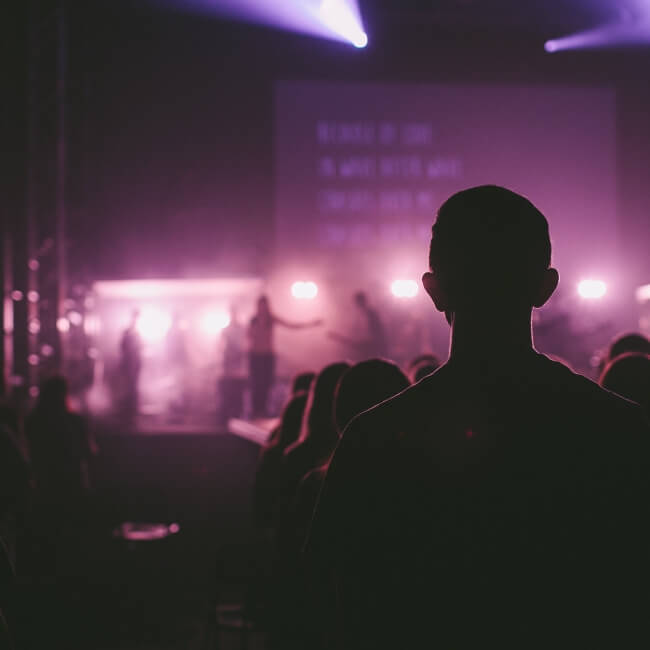 man standing at back of worship service