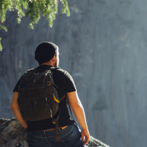 man hiking by cliff