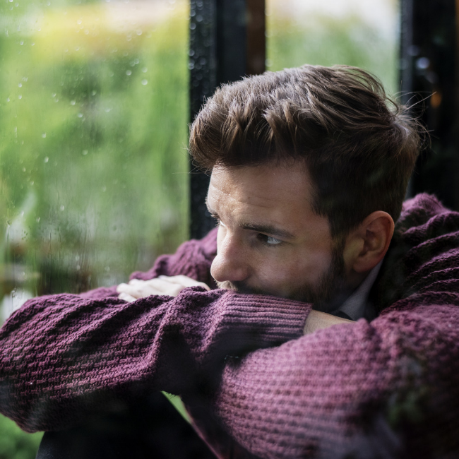 pensive man looking out window