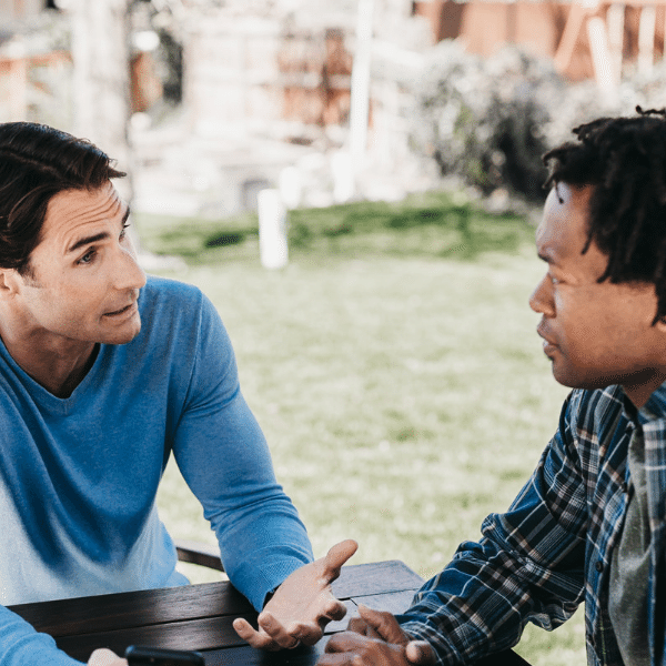 two friends talking at picnic table
