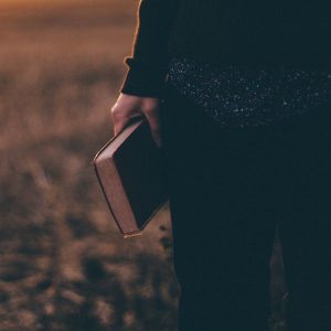 man holding bible by his side