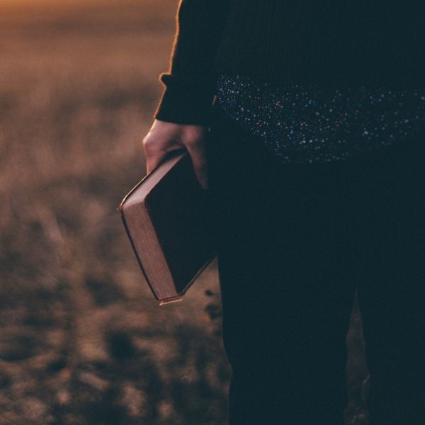 man holding bible by his side