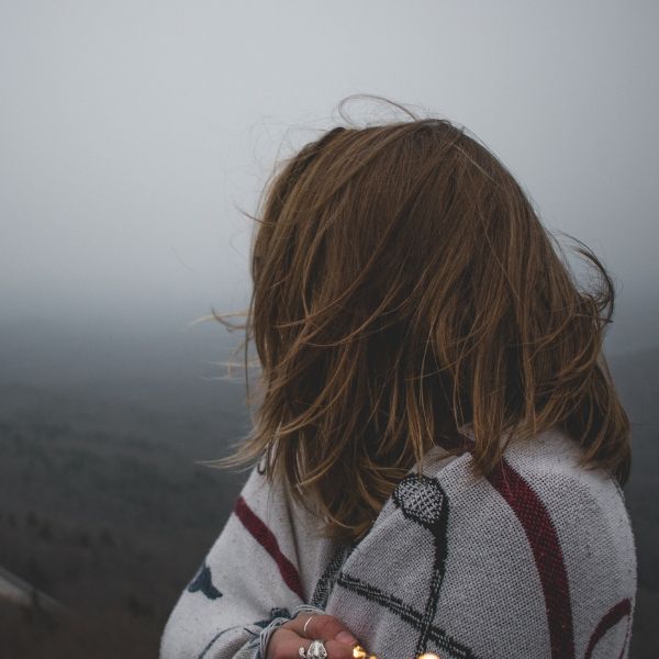 woman looking away toward fog