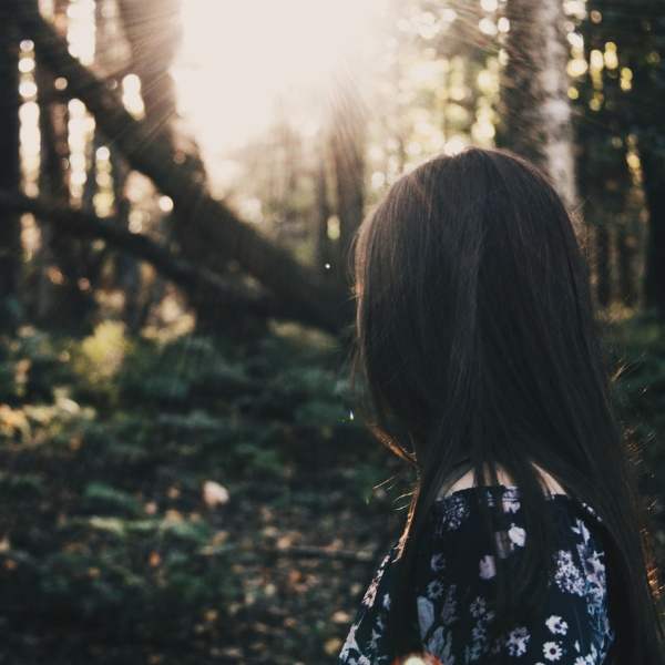 woman walking through forest alone