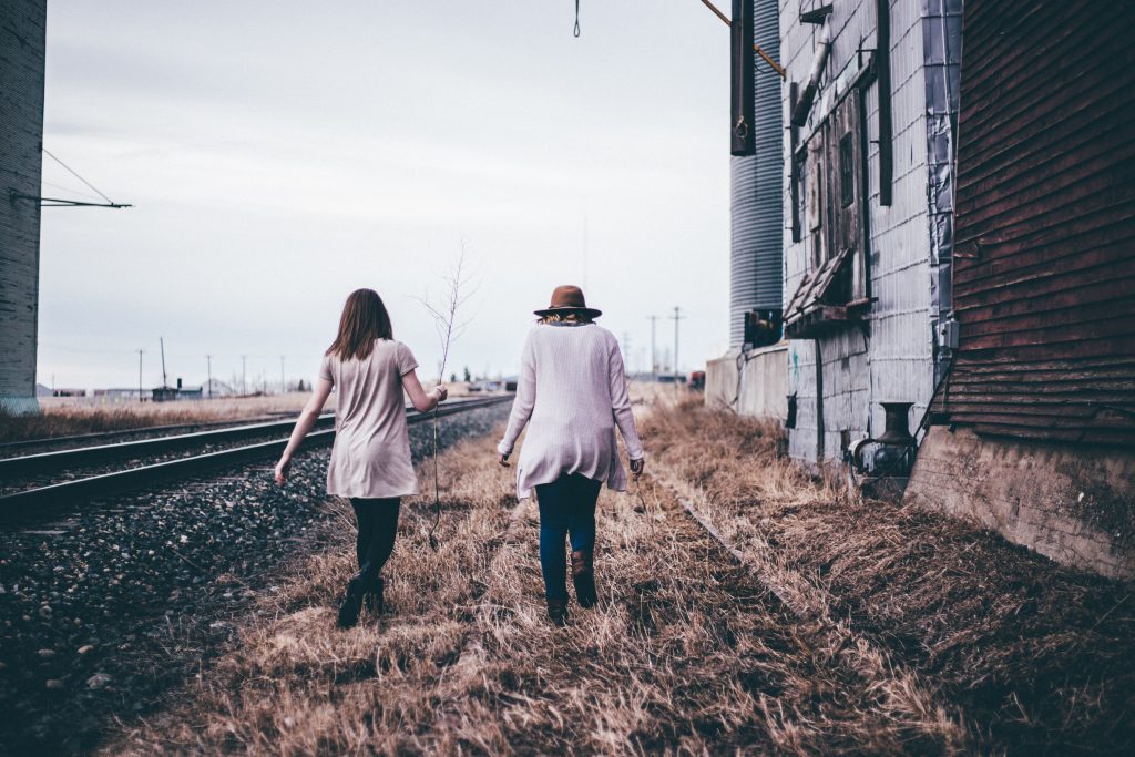 two girls walking in field