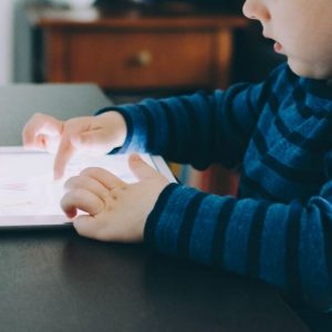 young boy on tablet at kitchen table