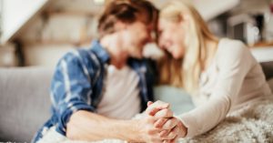 couple holding hands on couch