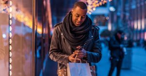 man doing holiday shopping on sidewalk