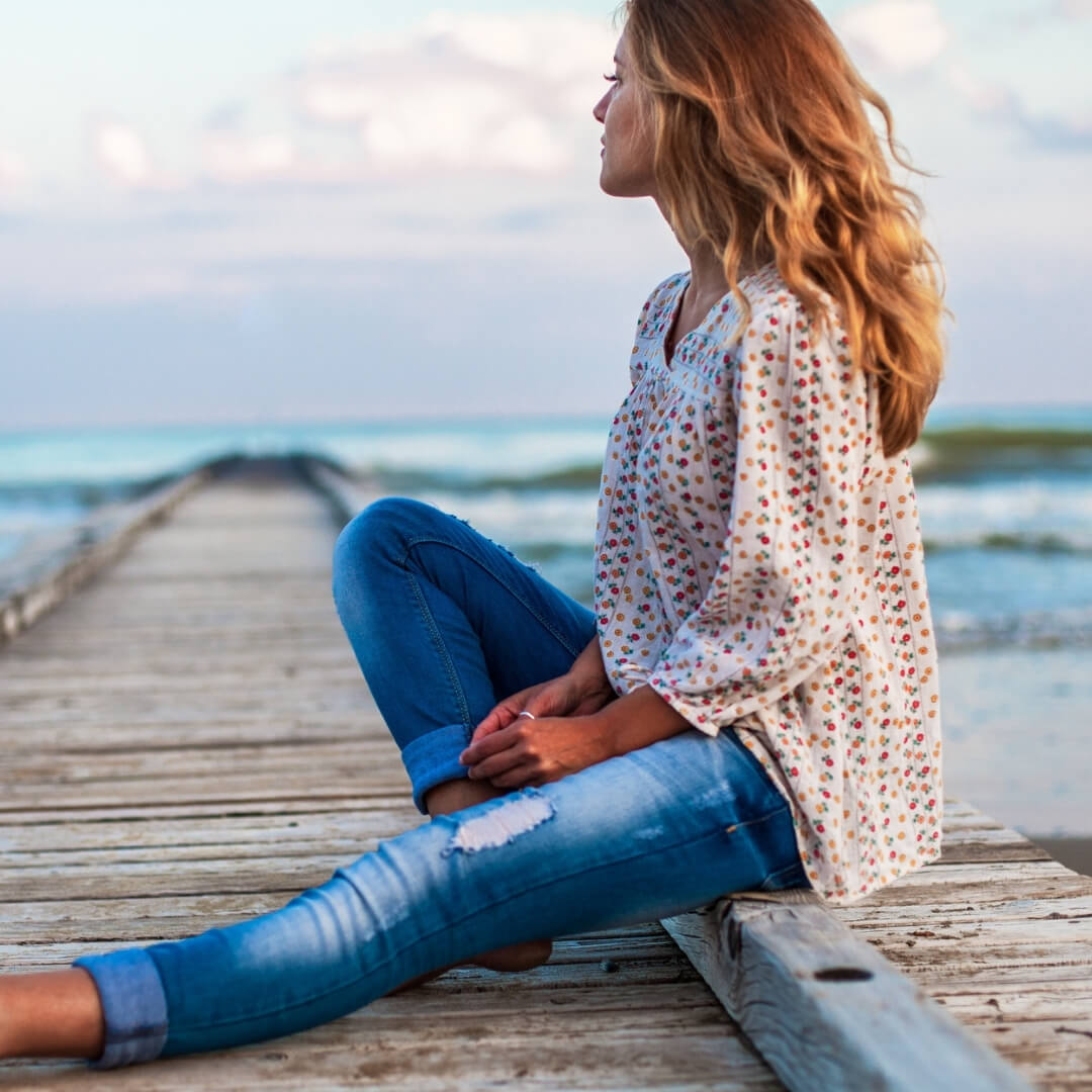 woman sitting on pier