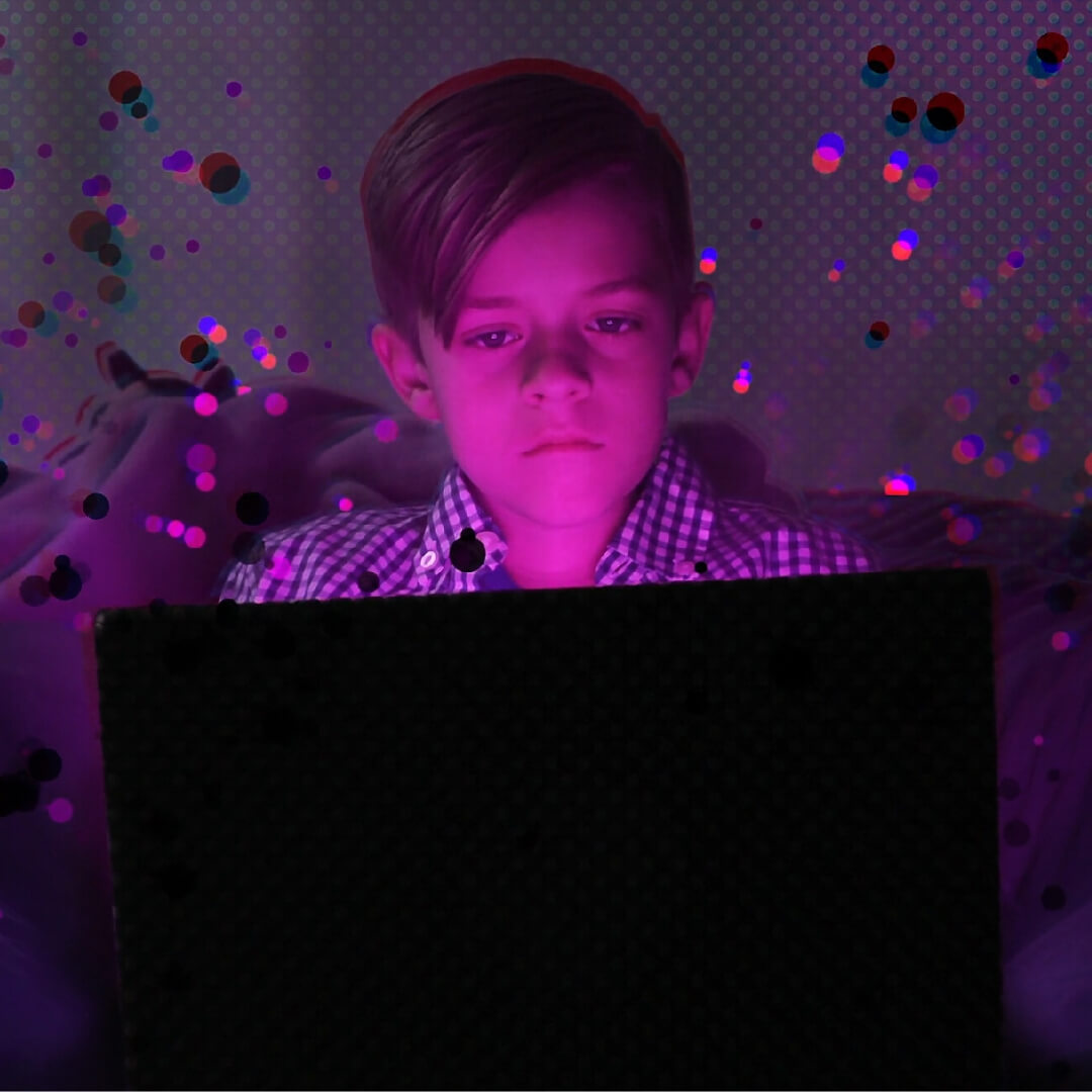 young boy looking at laptop with purple overlay