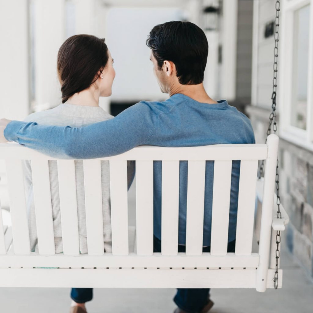couple talking on porch swing