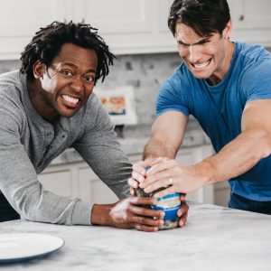 two men trying to open jar of pickles