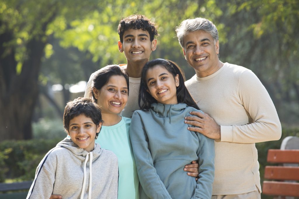 A happy family posing for a picture outside.