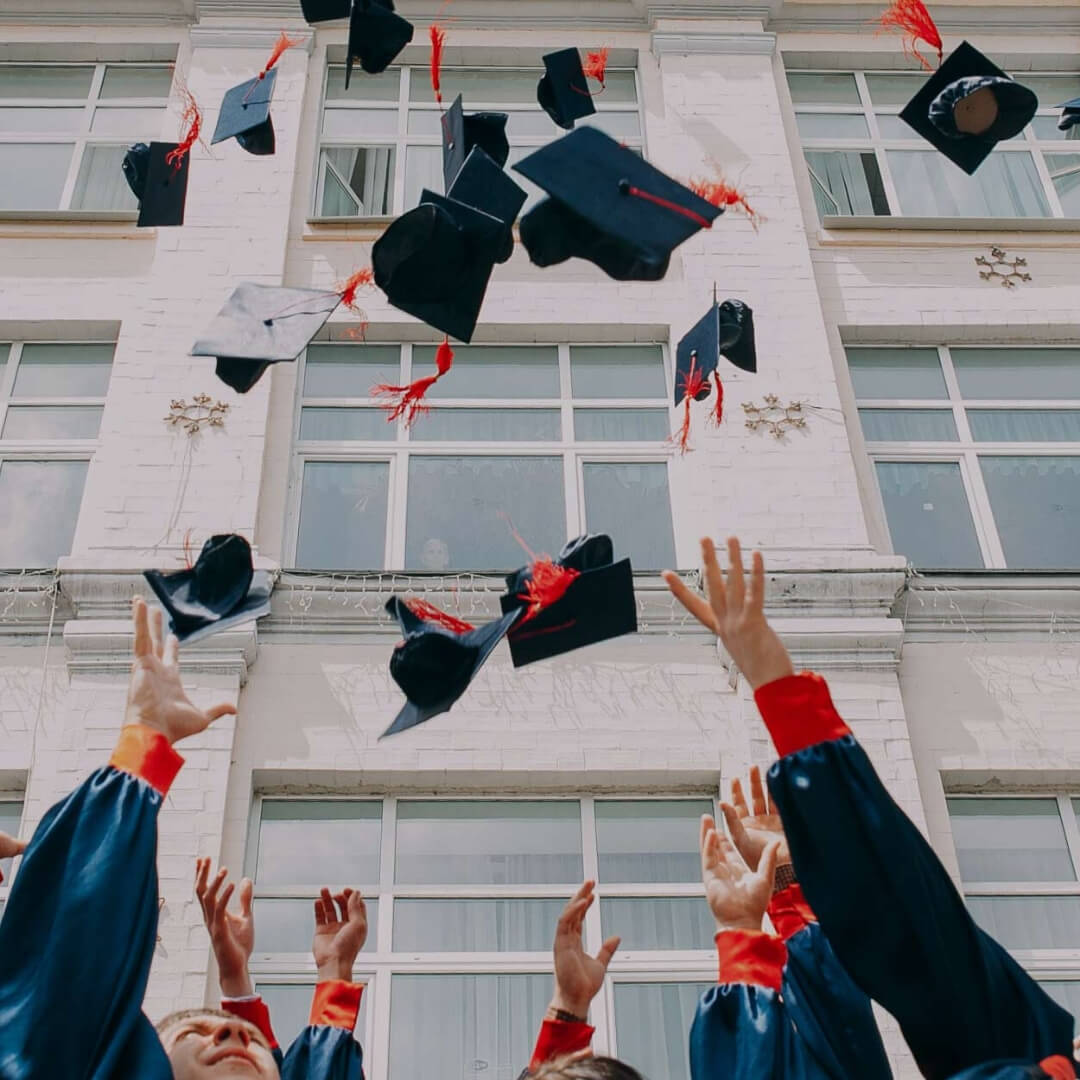 graduates throwing caps in air