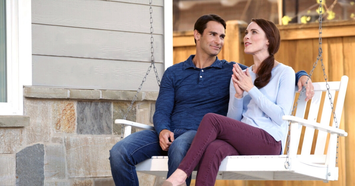 husband and wife talking on porch swing