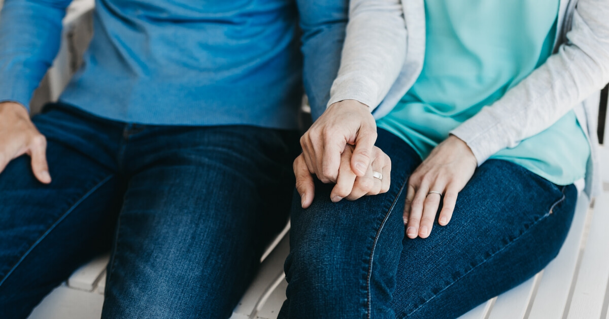 close up of husband and wife holding hands