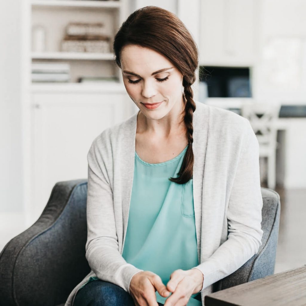 woman sitting in chair looking down alone