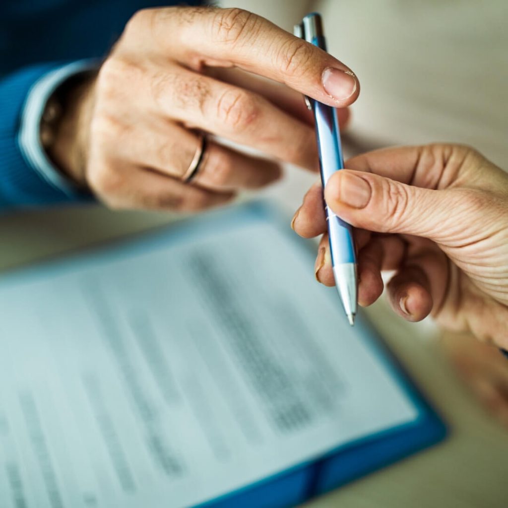 man holding woman pen to sign contract