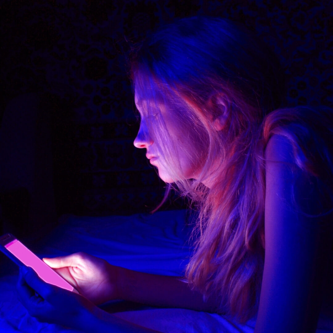 woman looking at phone with purple screen