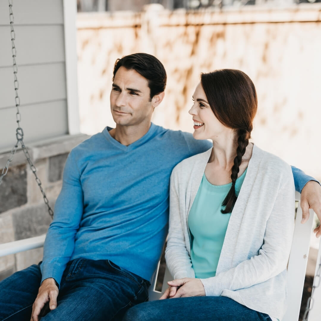 husband and wife talking on porch swing