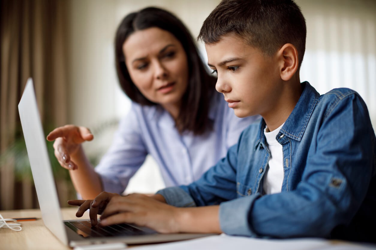 A mother and her son at the computer, talking about the dangers of pornography.