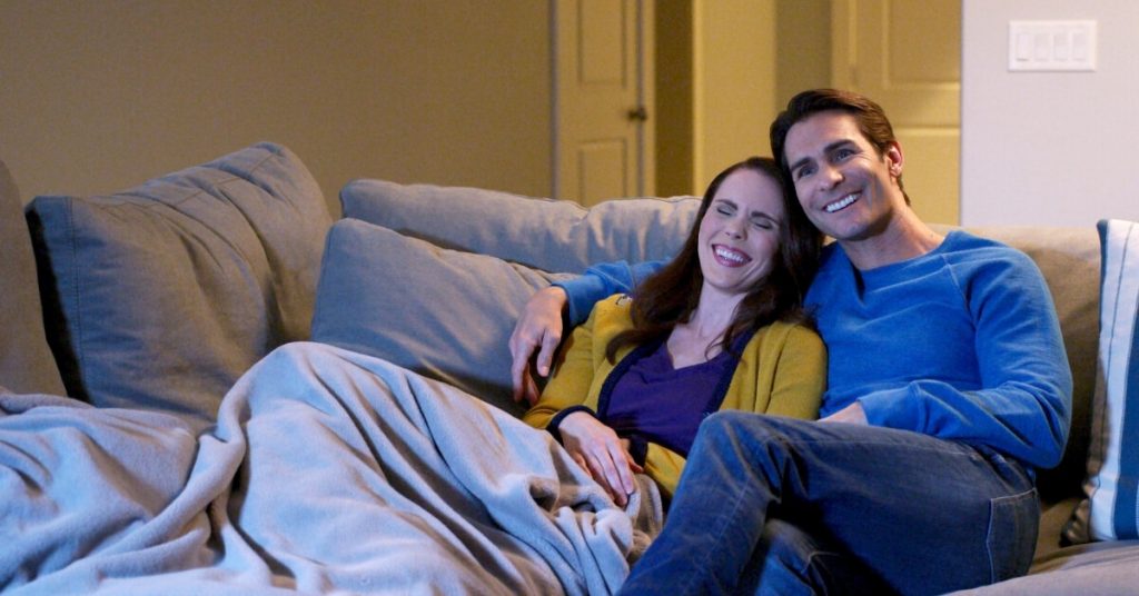 couple laughing while watching a movie