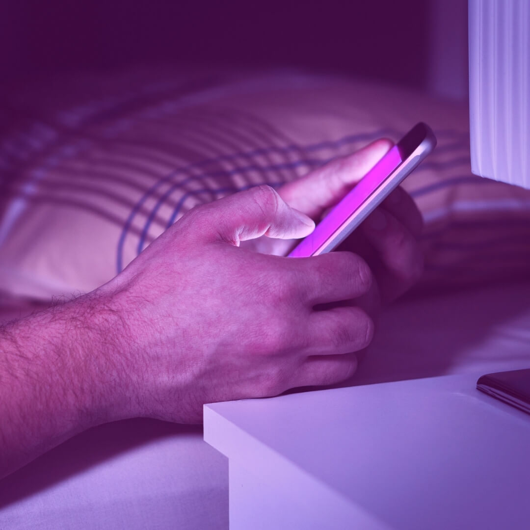 man looking at phone with purple screen