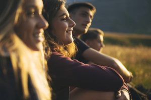 A group of young people outside telling stories at dusk