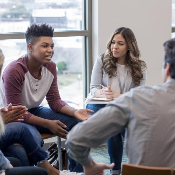 group of young people talking in a circle