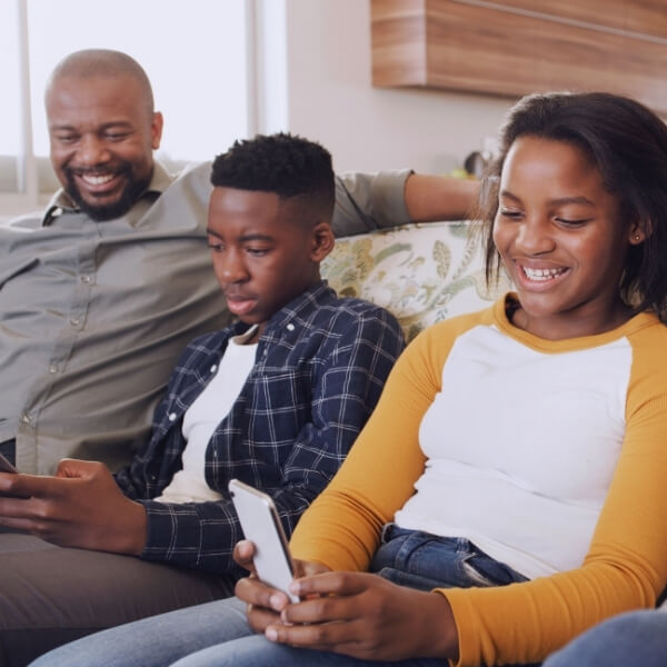 happy parents and teens looking at phones