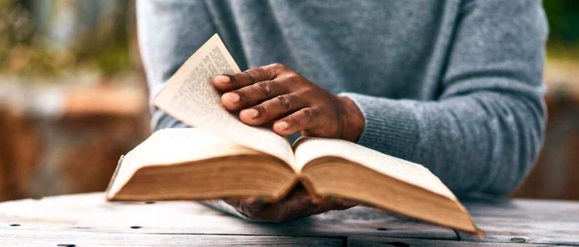 man praying over a Bible