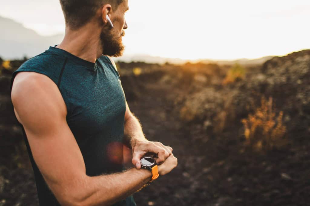 A distance runner checking the time on his watch.