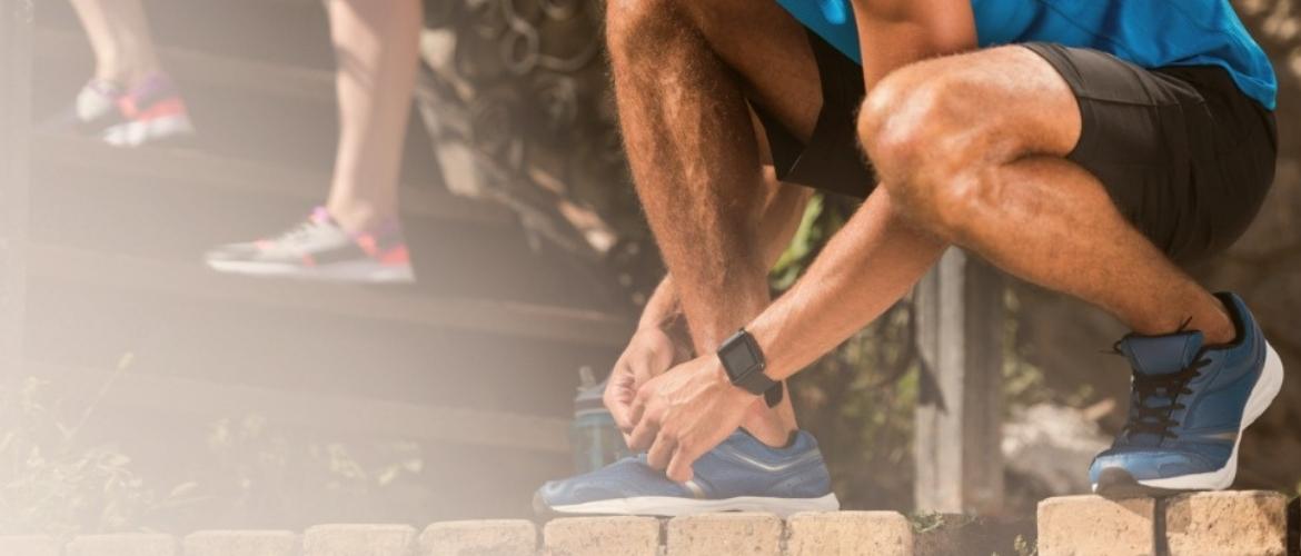 man tying shoes before exercise