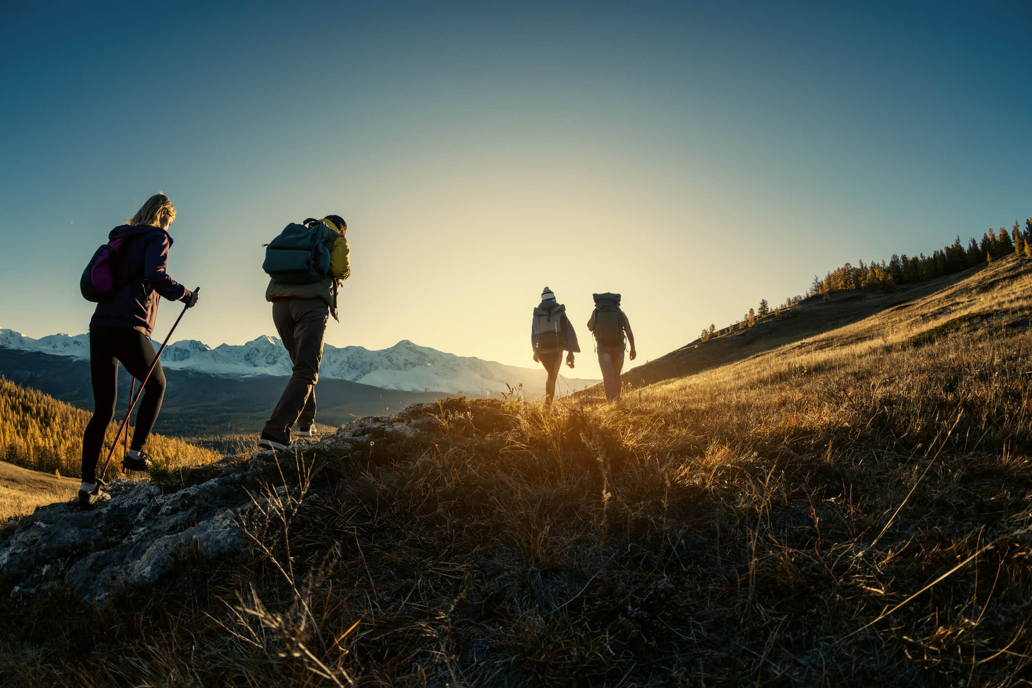 hikers at sunset climbing a mountain