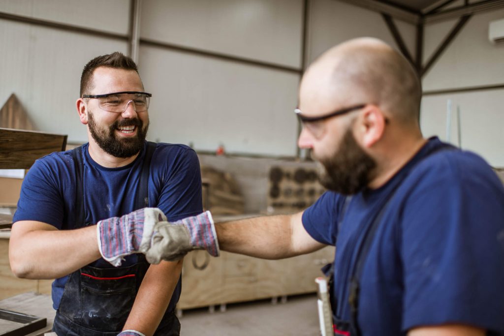 Two male workers bumping fists.