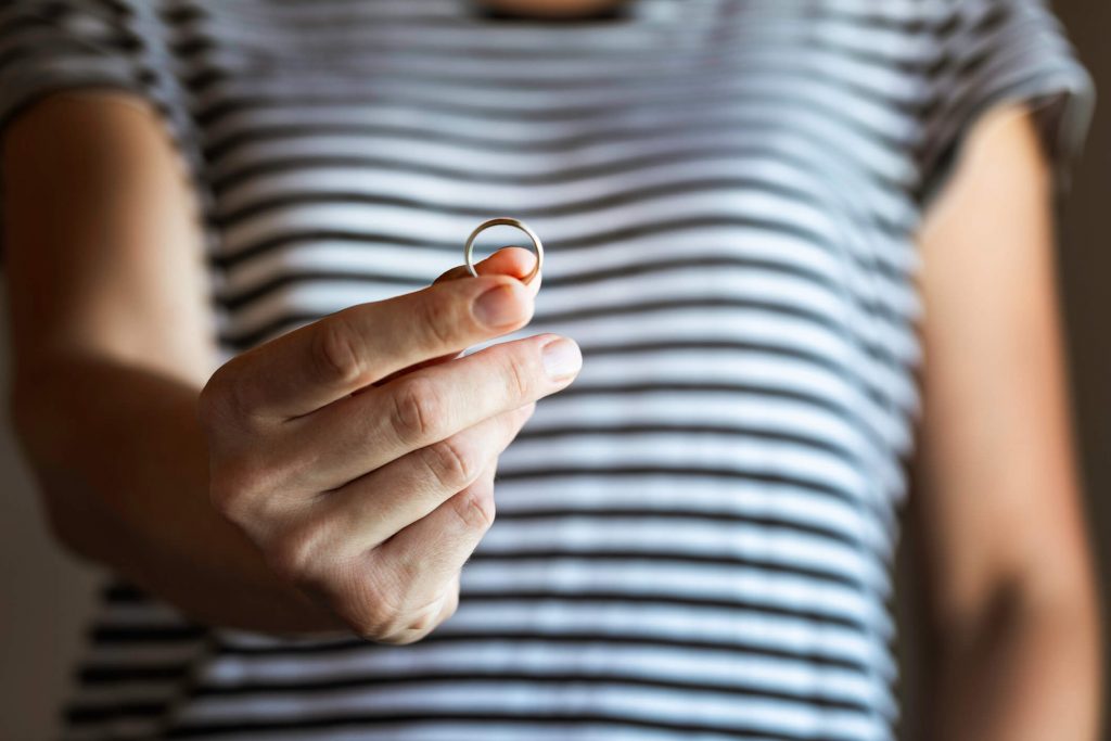 hand of a woman holding out a wedding ring