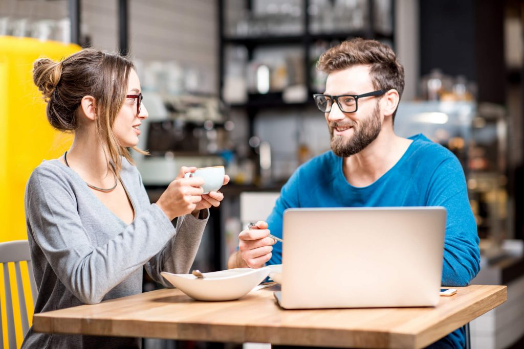 husband and wife in a cafe with a computer