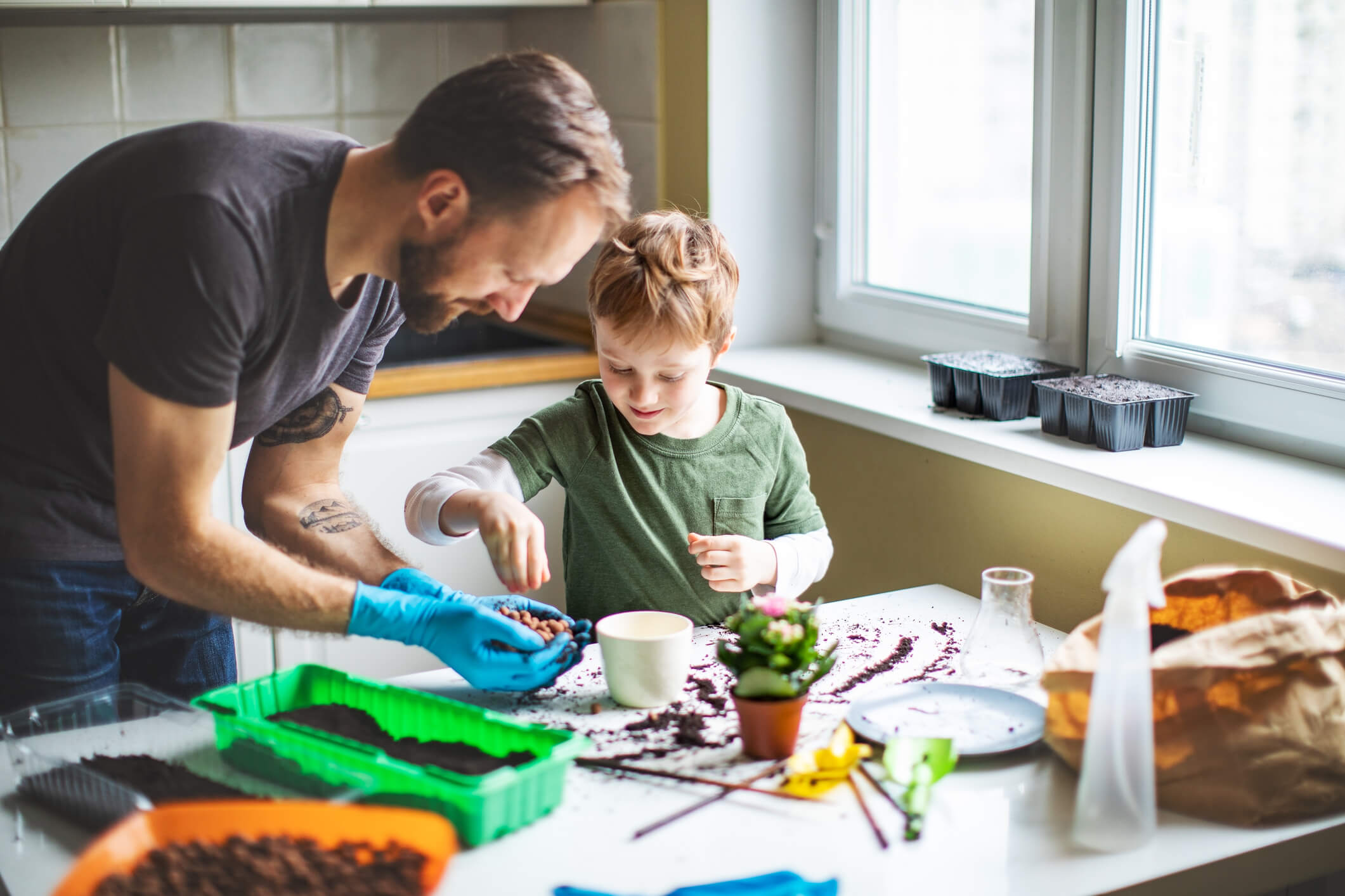 a father planting flowers with his son