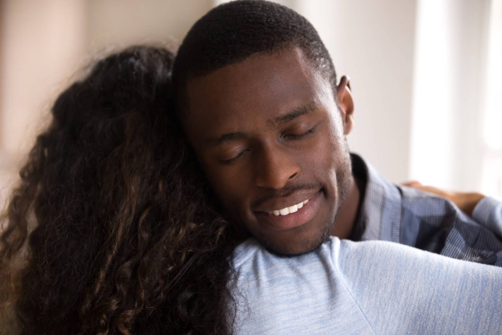 calm looking man embracing his wife